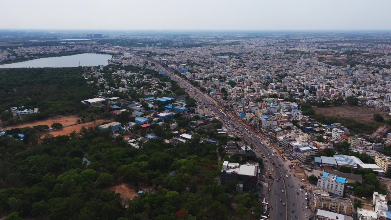 Veduta aerea di Ramachandrapuram con lago, Bhel township, autostrada di Mumbai e flusso di traffico a Chanda Nagar, Lingampally, Hyderabad, Telangana, India. Di giorno, ripresa statica, ripresa con drone, 4k