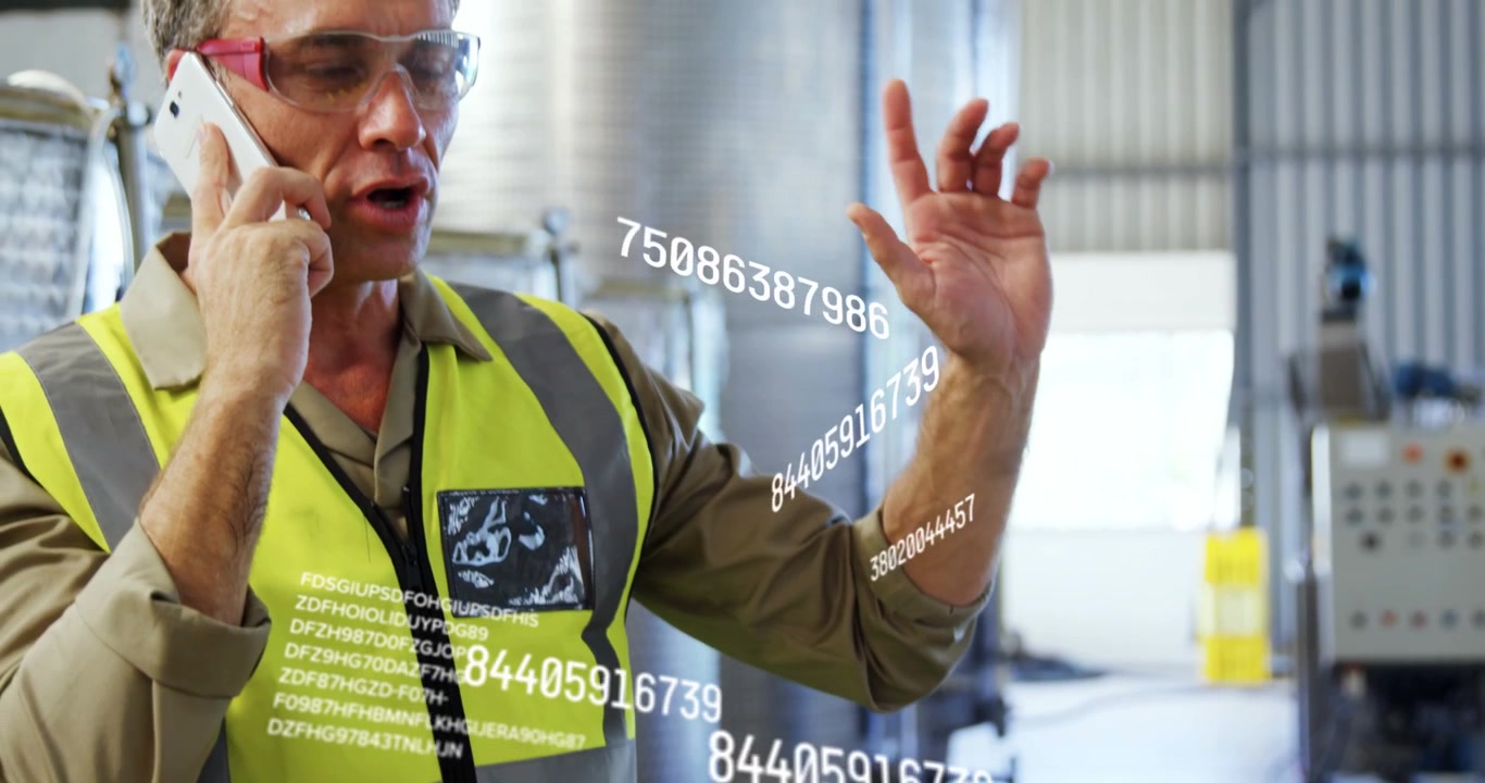 Vertical video: Answering call operator in hivis vest on phone, gesturing, discussing data by tanks