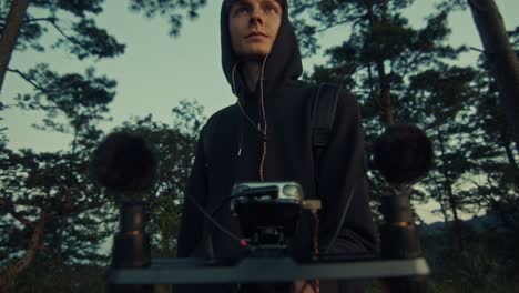 person recording audio with drone in forest