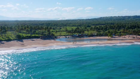 Aerial-shot-in-salty-stream-overlooking-the-river-joining-the-beach-on-a-sunny-afternoon