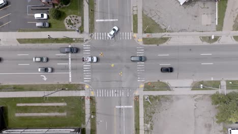 cars moving at the intersection of cedar street and saginaw highway in lansing, michigan with overhead drone video