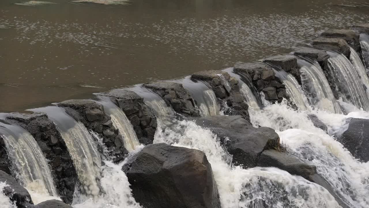 강력한 강물이 흐르는 슬로우 모션 암석 인공 위어