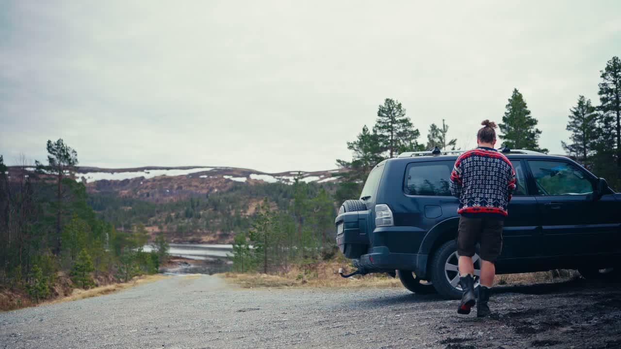 A Man Takes a Backpack Out of a Car Parked by the Shores of Reinsjøen in Åfjord, Trøndelag, Norway - Static Shot