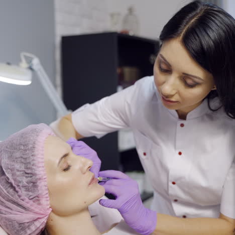 beautiful young woman gets injection in lips. beauty injections and cosmetology. plastic and aesthetic surgery.