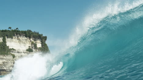 wave crashes into whitewater in smooth slow motion, sunlight glints on turquoise water