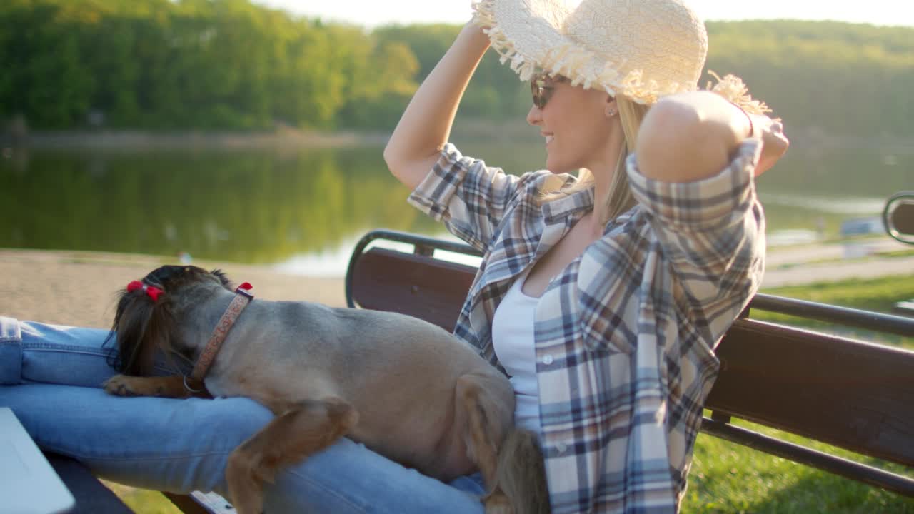 어린 여자가 개와 함께 벤치에서 휴식을 취하고 있습니다.