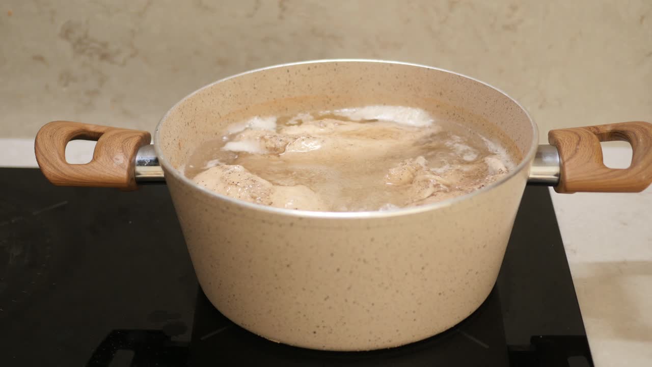 Pollo in ebollizione in una pentola