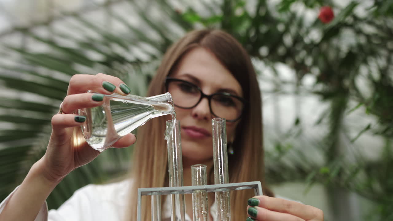 Ung, kvindelig videnskabskvinde, der arbejder med planter og udfører tests for at udvikle moderne medicin fra forskellige planter