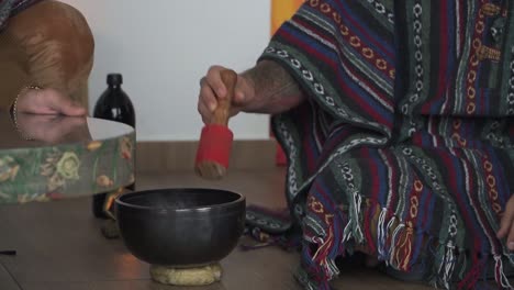 yogi using tibetan singing bowl during meditation session