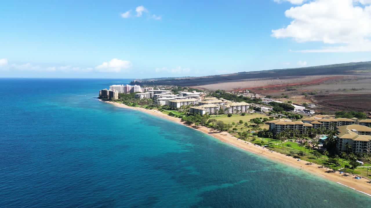 High-angle aerial of Lahaina shoreline resorts with scorched interior beyond