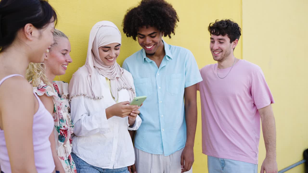 Diverse group of friends looking at a phone together