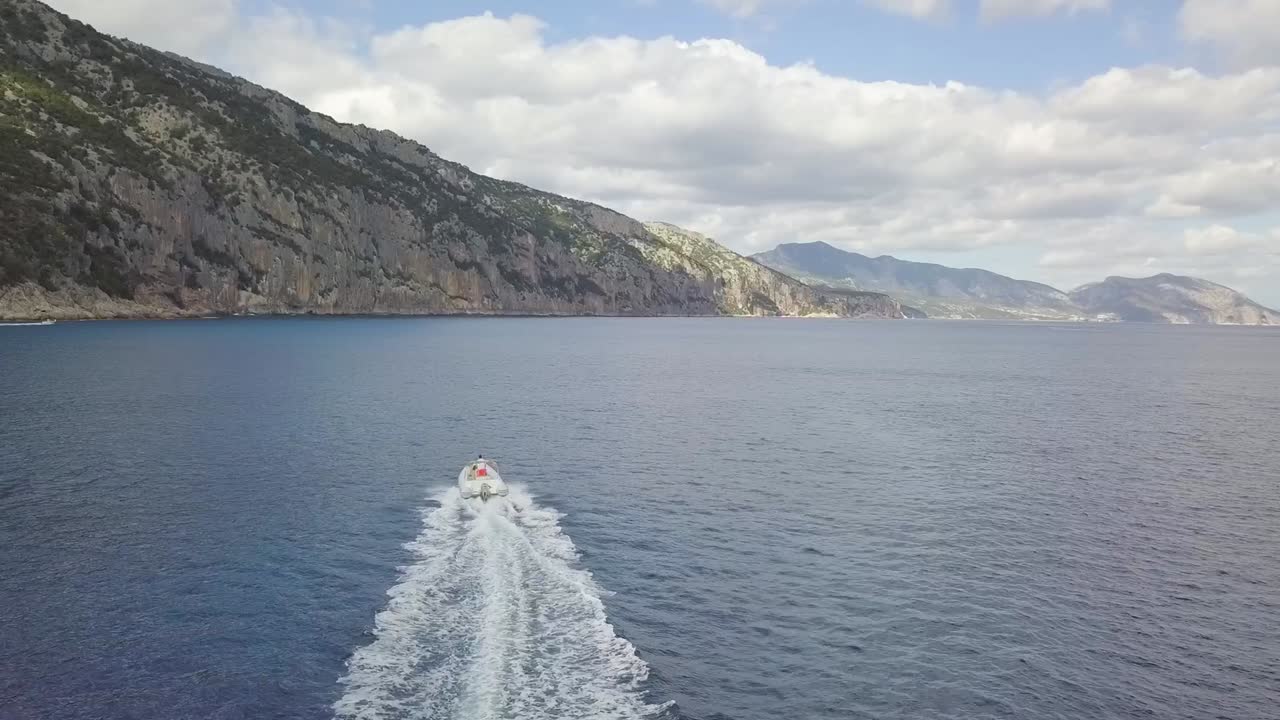 Vista aérea de una lancha motora en la costa de Cala Gonone, Cerdeña, Italia.