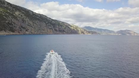 Vista-Aérea-De-Una-Lancha-En-La-Costa-De-Cala-Gonone,-Cerdeña,-Italia