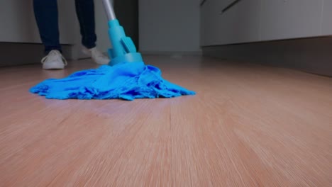 woman mops parquet floor at home