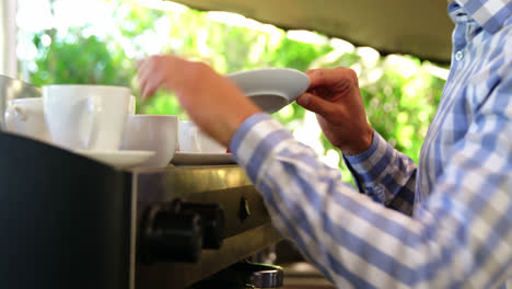 male owner arranging cup and saucer