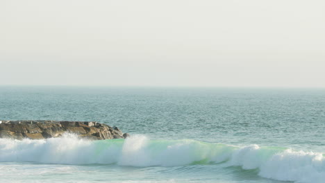 strong waves hitting the rock edge of figueira da foz city in portugal -wide