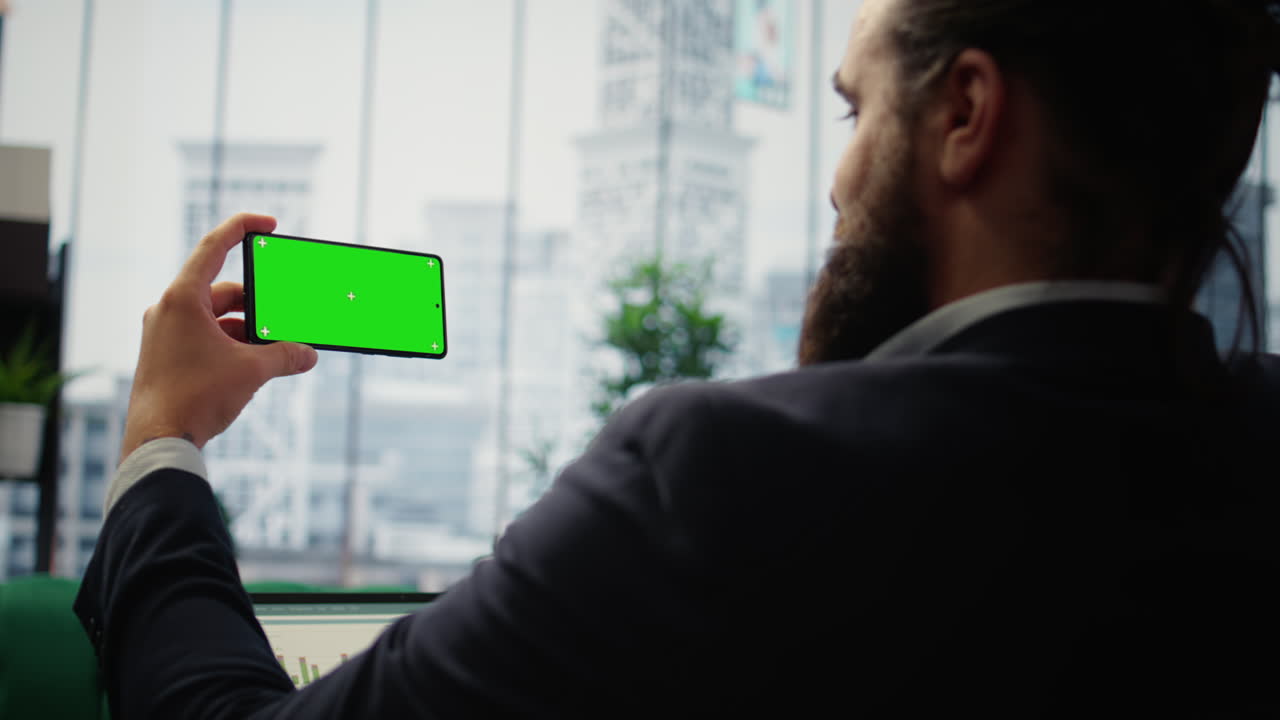 Vertical Video Focused chief executive officer looks at chroma key display on phone