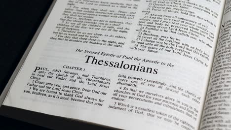 close up shot of bible page turning to the book of second thessalonians