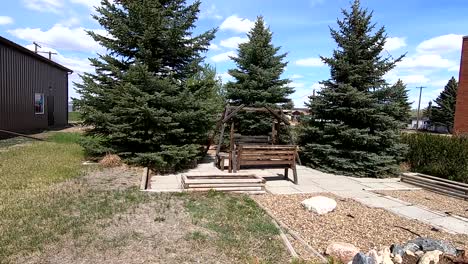 wooden swing set in the sitting area of a park on a sunny day