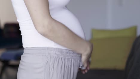 closeup shot of pregnant woman rubbing belly