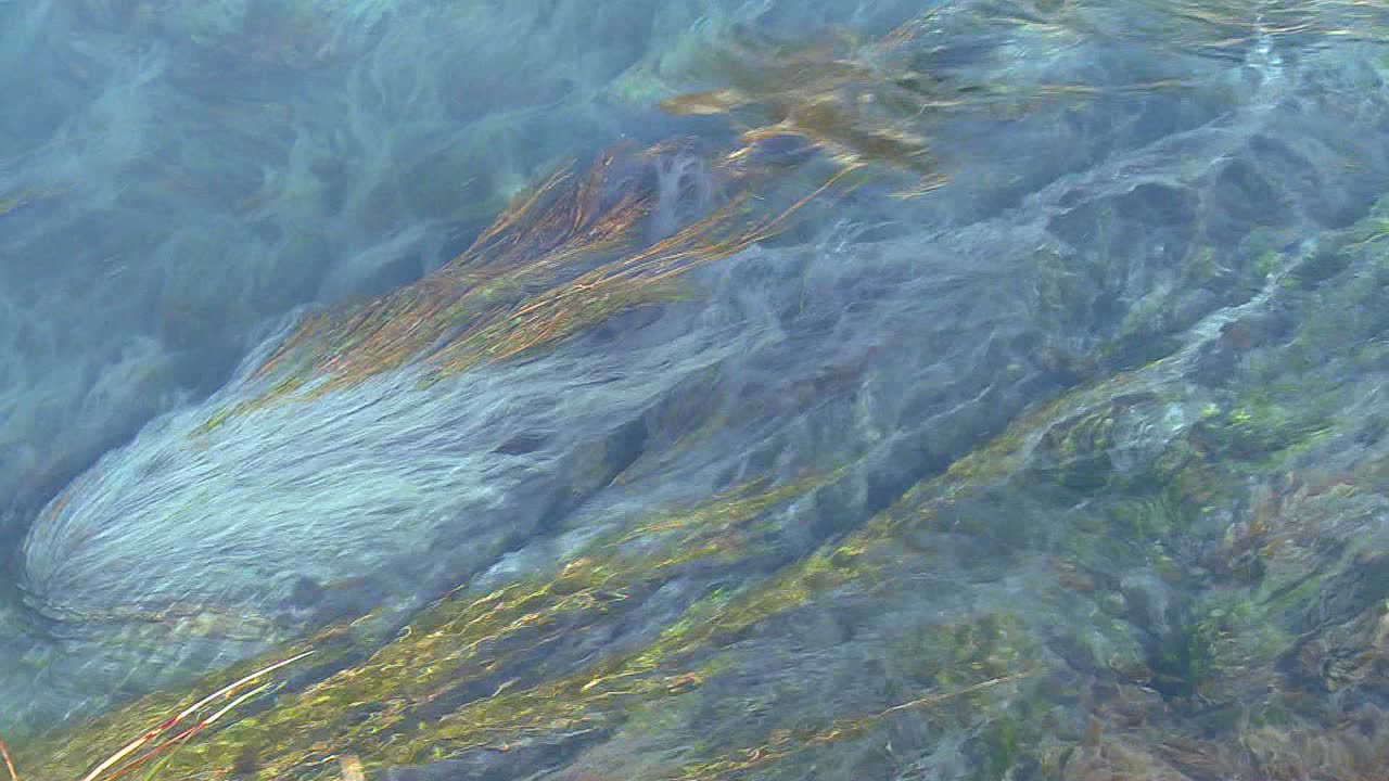 el agua azul fluye en un arroyo de montaña en hermosos patrones abstractos 1