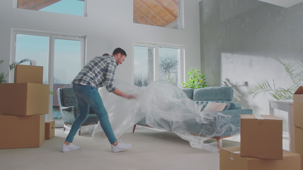 pareja quitando la cubierta del sofá