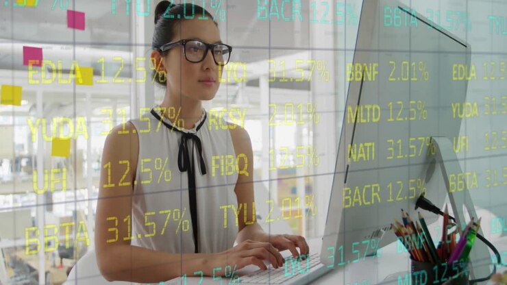 Animazione di un reticolo e un tabellone di trading su una donna birazziale che lavora al computer in ufficio