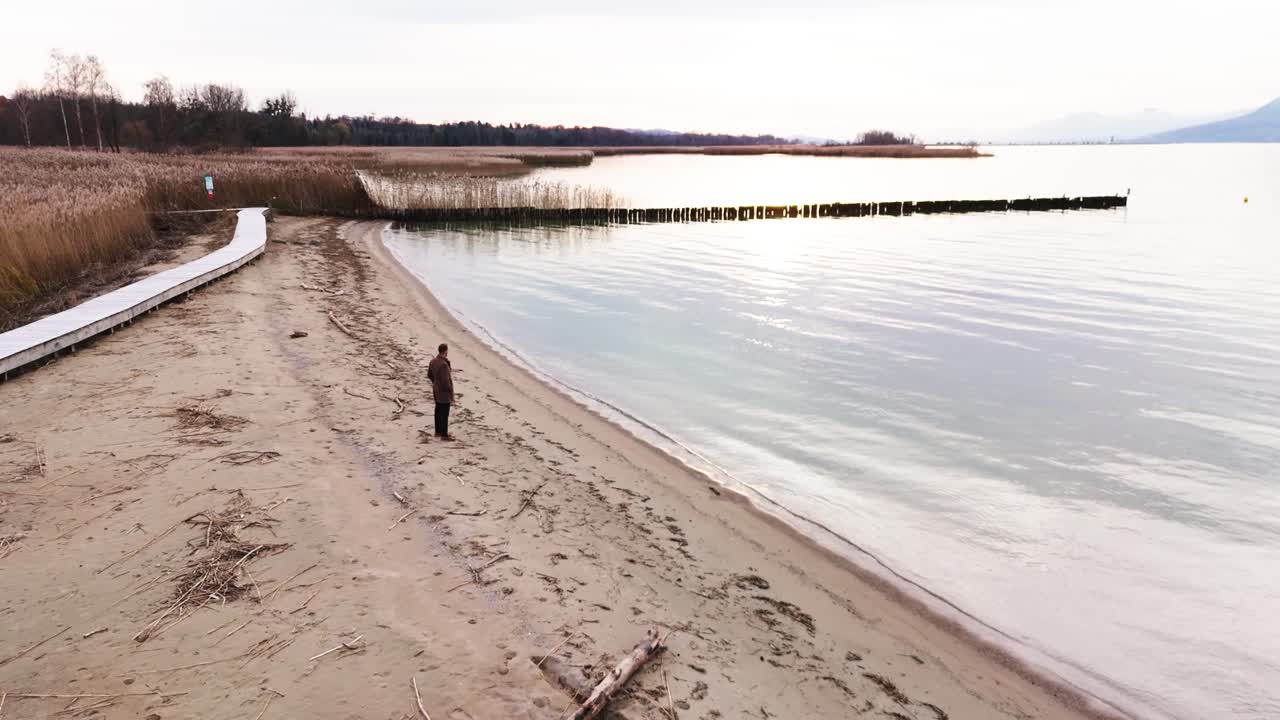 한 남자가 해변에 혼자 서 있습니다.