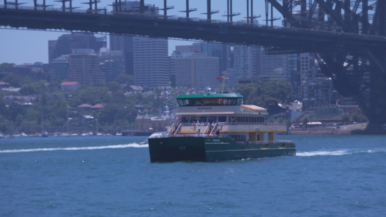 시드니 의 페리 가 시드니 오스트레일리아 의 하버 브릿지 를 배경 으로 한 밝은 빛 날 에 서클러 케이 에 도크 에 들어간다