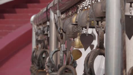 bells swinging in the wind at buddhist temple. near focus. slow motion.