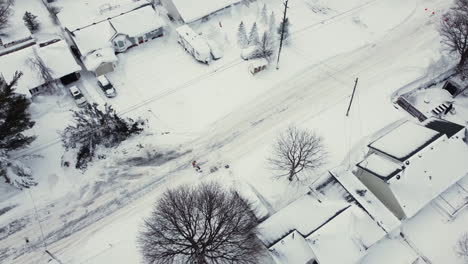 Drohnenansicht,-Vogelperspektive-Von-Oben-Nach-Unten,-Ansicht-Einer-Person,-Die-Schnee-In-Einer-Einfahrt-Bewegt