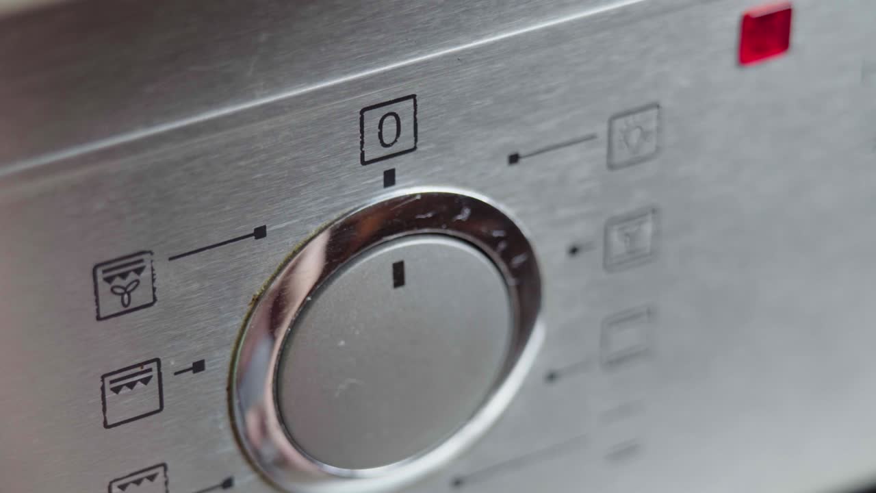 interruptor de conmutación metálico del horno de cocción de primer plano. panel frontal del horno moderno. encendiendo la estufa, horno de horneado y cambiando los modos para precalentar y cocinar la comida