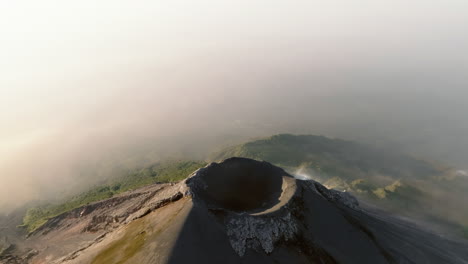 slow drone orbit shot of active fuego volcano crater in guatemala during sunrise