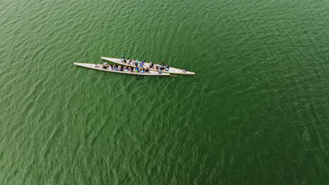 a rotating drone shot over two boats over a large asian river on a cloudy day