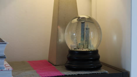 a snow globe with models of buildings in the twin cities in minnesota and snow flakes falling