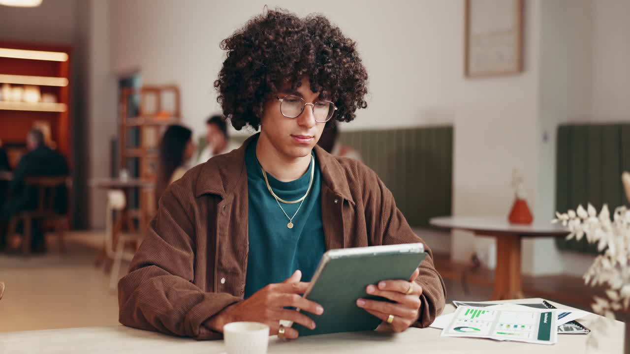 Portrait of a smiling man with curly hair in a cafe