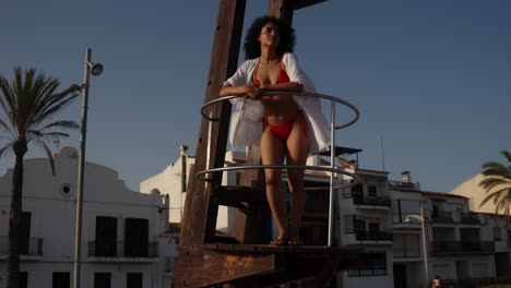 woman in red bikini on lifeguard stand