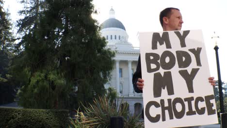 male political protester with my body my choice sign