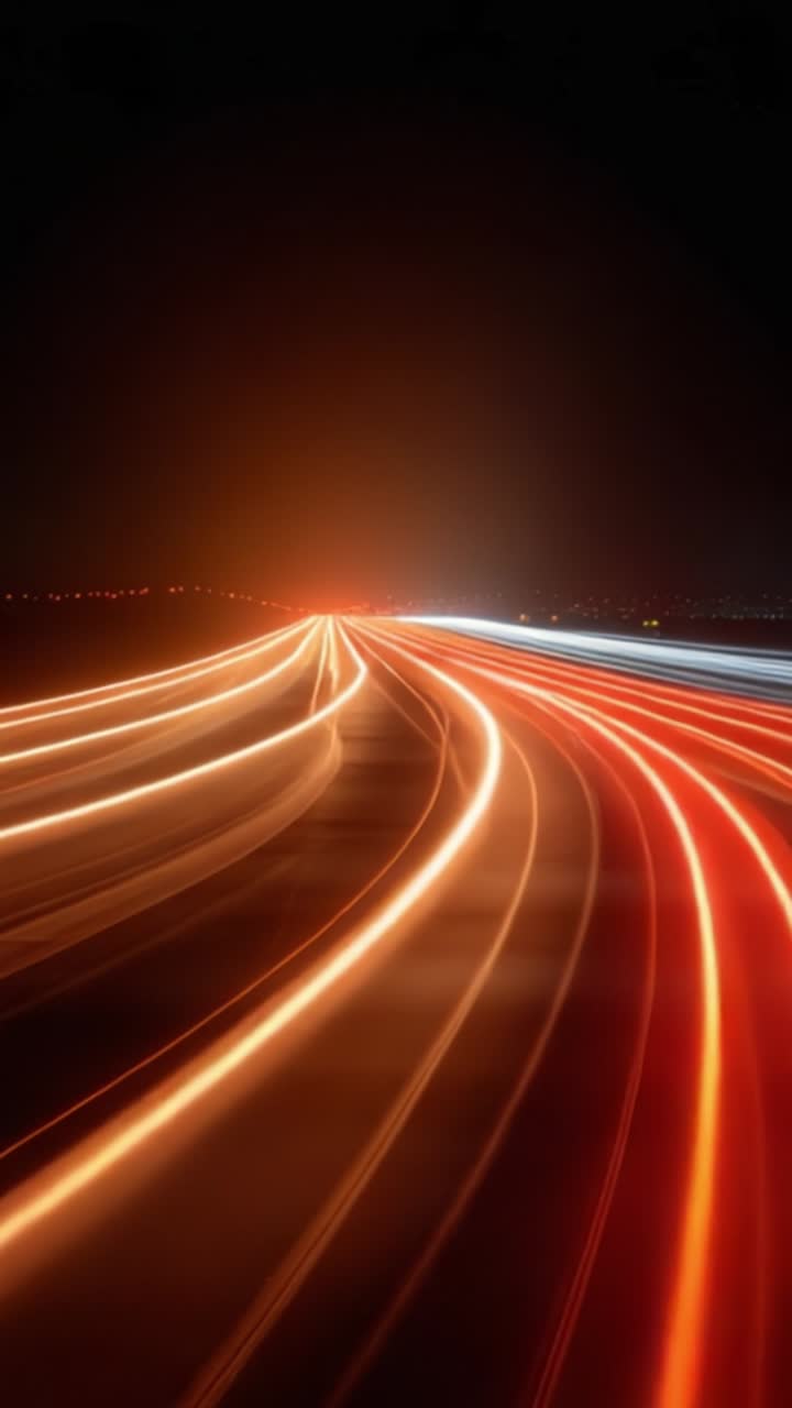 Scie luminose dinamiche notturne che catturano il flusso del traffico con brillanti strisce rosse e bianche su un'autostrada scura, creando un senso di velocità e movimento.