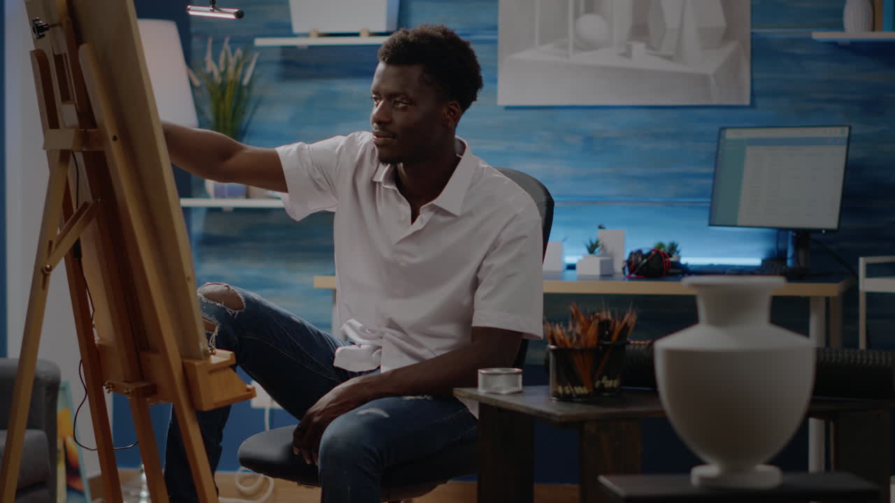 African american creative man using vase for drawing inspiration
