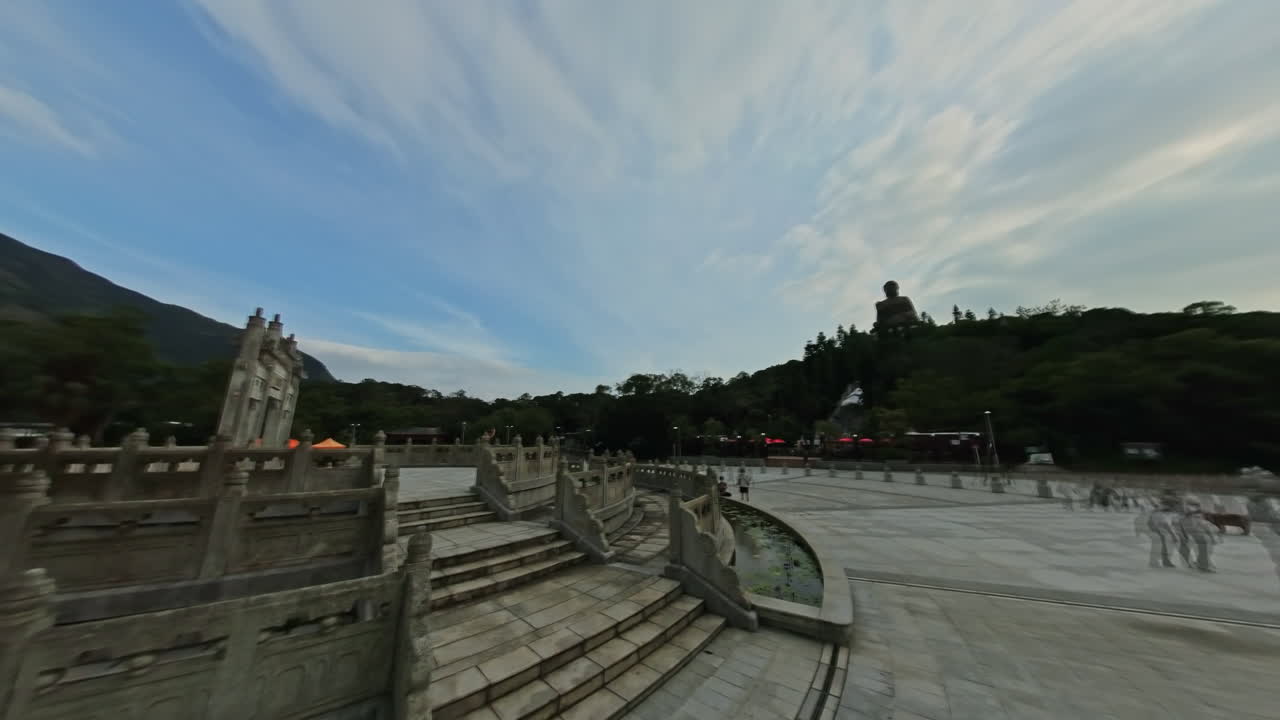 Panning motion time lapse clouds in blue sky flying over Big Buddha