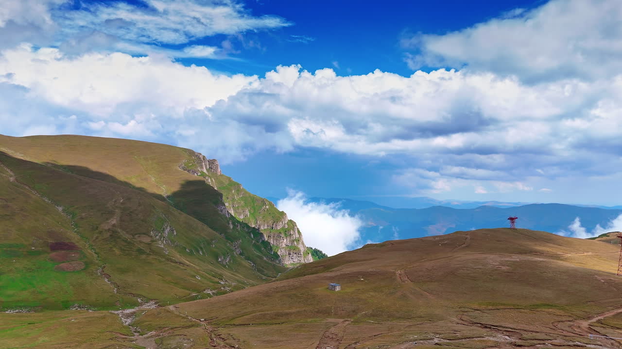 Caraiman Plateau with grassy ridges and trails. Grassy slopes and ridges of the Caraiman Plateau stretch across the Carpathians in Romania