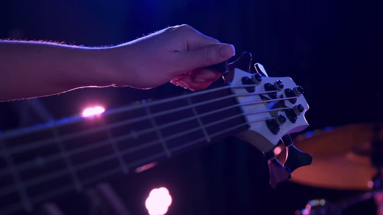 Musicista donna che accorda la chitarra prima del concerto