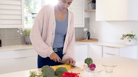 indian woman chopping vegetables in modern kitchen, preparing healthy meal