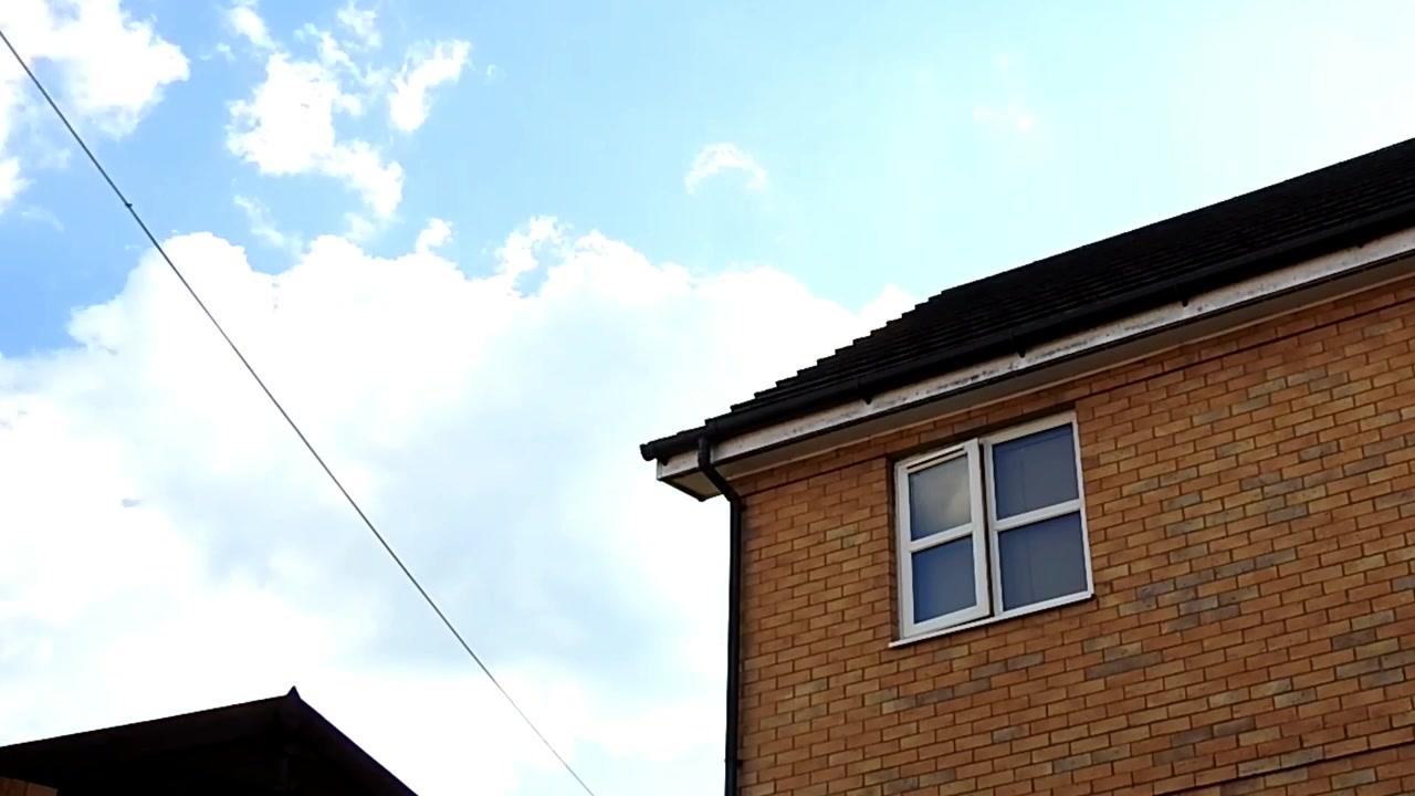 En time-lapse av skyer i forskjellige former og farger som passerer over hus i England, Storbritannia