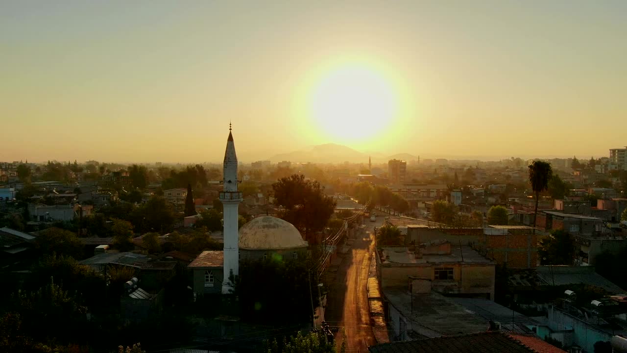vuelo sobre la ciudad musulmana con minarete de la mezquita y edificios residenciales.