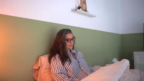 Content-mature-woman-in-sleepwear-reading-book-on-bed