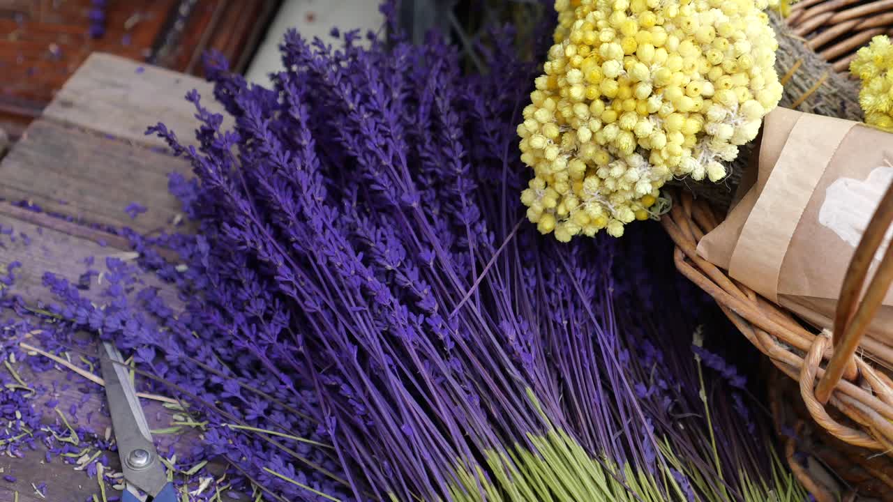 un ramo de lavanda seca y flores amarillas en una canasta
