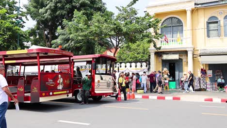 red bus passing by a historic building