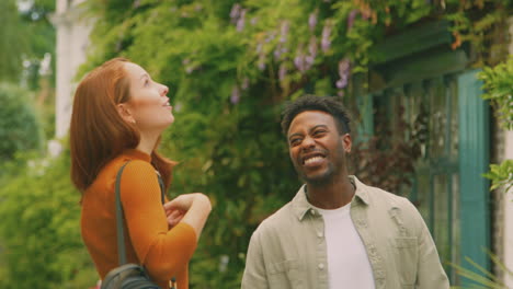 young couple of vloggers or social influencers travelling through city street for social media